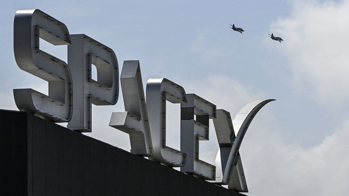 US billionaire businessman and pilot Jared Isaacman flies in formation aboard a fighter jet over the SpaceX sign, close to the Starship spacecraft, before his third test flight from Starbase in Boca Chica, Texas, on March 13, 2024. Elon Musk's SpaceX announced it was eyeing March 14 as the earliest date for the next test launch of its giant Starship rocket, with which it hopes to one day colonize Mars. Two previous attempts have ended in spectacular explosions, though the company has adopted a rapid trial-and-error approach in order to accelerate development. (Photo by CHANDAN KHANNA/AFP via Getty Images)