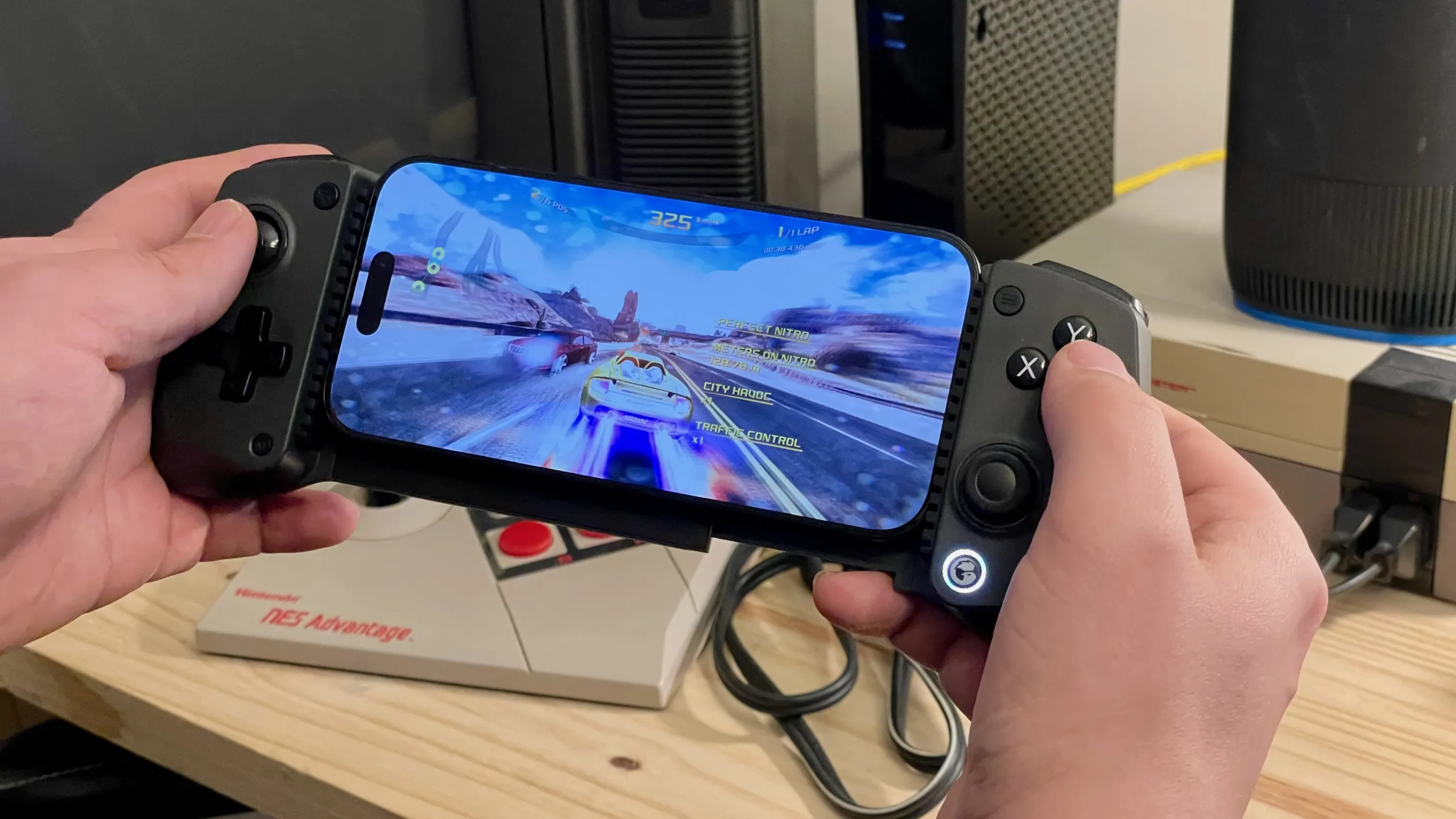 Playing Asphalt 8 on an iPhone in a GameSir X5s controller, in front of an NES